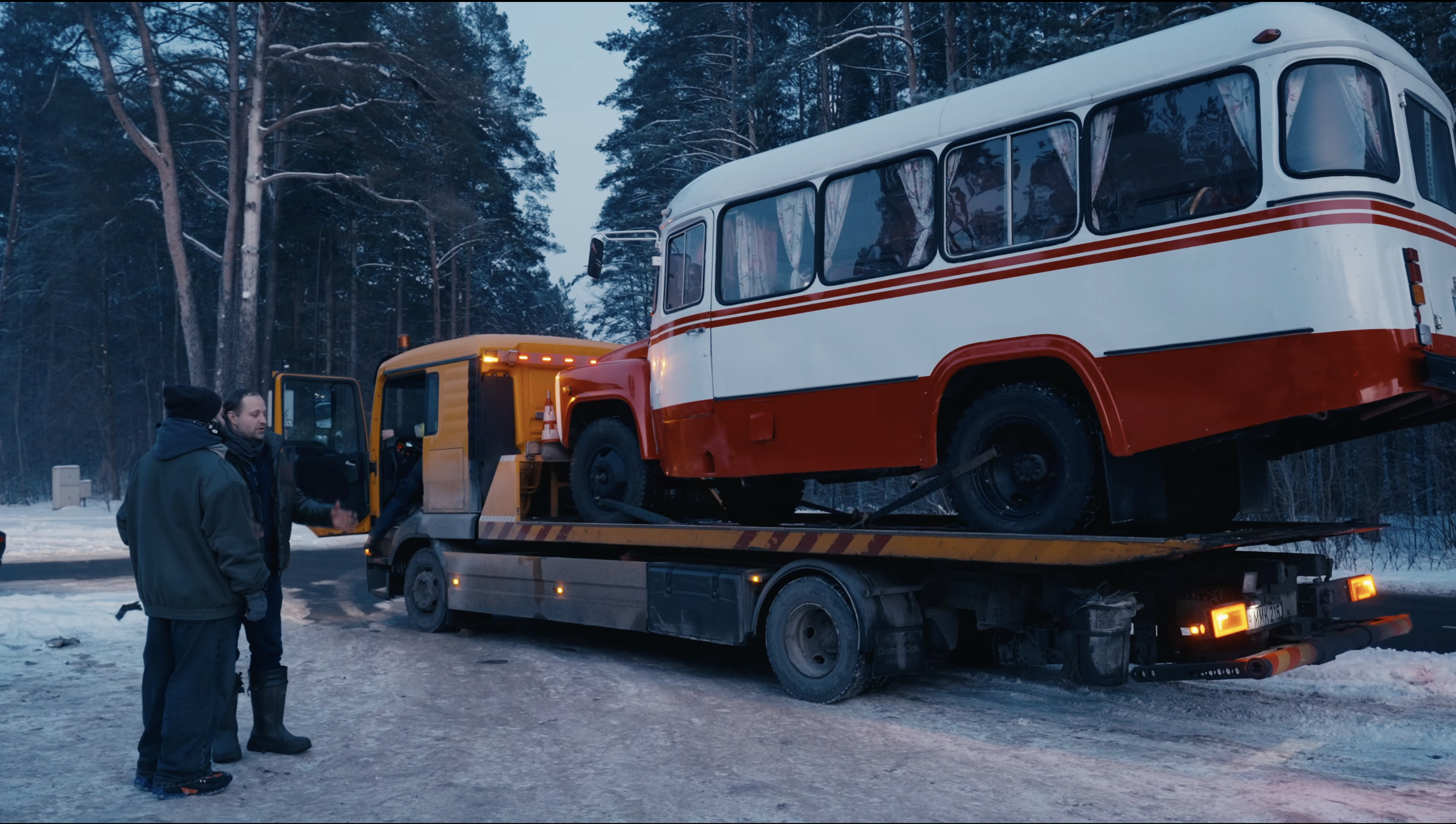 Vintage bus on a transport truck in the snow